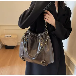 Detail of vintage brown leather tote bag with pleated top and golden ring hardware