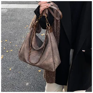 Detail shot of brown faux suede hobo bag with vintage texture and metal chain strap