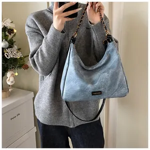 Light blue faux leather bag with vintage texture and gold chain strap detail
