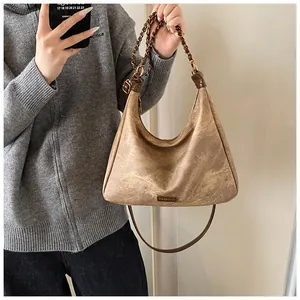Close-up of vintage brown faux suede hobo bag with gold chain and FASHION metal plate