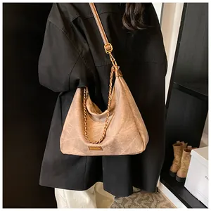 Close-up of a vintage brown crossbody bag featuring metal chain and FASHION tag detail