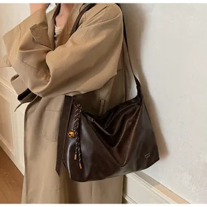 Détails du sac fourre-tout marron souple avec texture et breloque en forme de cloche