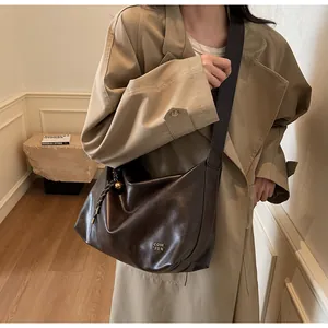 Vue détaillée du grand sac hobo marron foncé avec logo métallique pour le travail