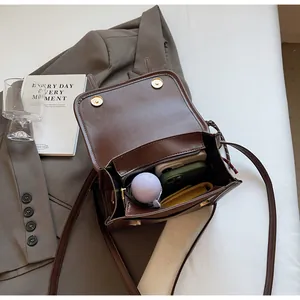 Vue intérieure du sac bandoulière en cuir marron avec double boucle magnétique et espace