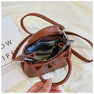 Vue de dessus de l'intérieur d'un sac en cuir marron avec doublure grise et zip argenté