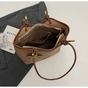 Close-up of khaki bucket bag interior with striped lining and zipper pocket