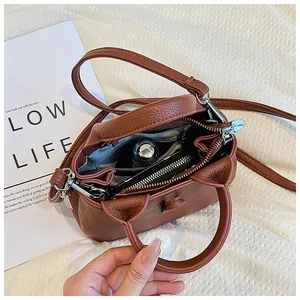Détails de l'intérieur du sac bandoulière en cuir marron avec objets