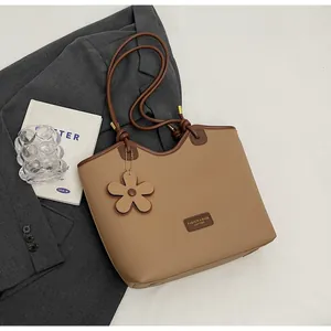 Detail of camel bucket bag with lychee pattern, flower pendant and inner pouch
