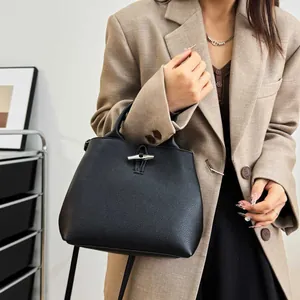 Sac à main chic en cuir noir avec fermoir bambou argenté et bandoulière amovible