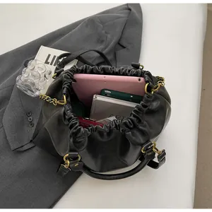 Detail view of the black pleated handbag interior showing ample storage for a tablet and phone