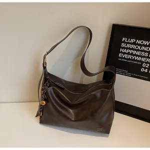 Détail du grand sac hobo marron foncé avec boucle dorée et texture en cuir souple