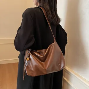 Grand sac cabas en cuir marron brillant avec pendentif doré et logo chic