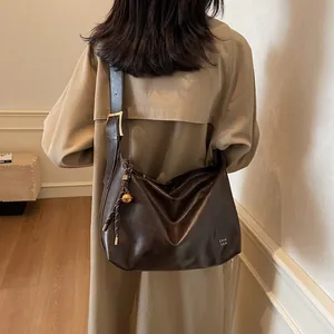 Grand sac cabas en cuir marron foncé brillant avec détails dorés pour femme active