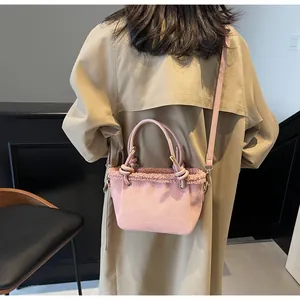 Close-up of pink frosted leather bucket bag with fuzzy sheepskin trim and round handle