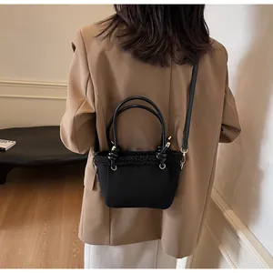 Detail of black crossbody bag with faux shearling trim and gold metal hardware