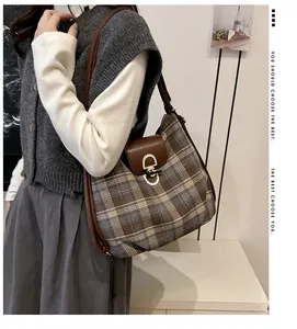 Nahaufnahme der Retro-Karo-Stofftextur und des hochwertigen braunen Leder-Schultergurts
