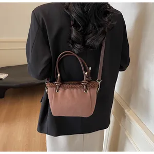 Brown frosted leather bucket bag with fuzzy faux fur trim shown being worn cross-body