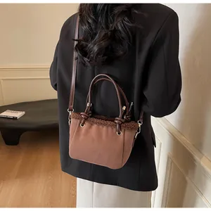 Close-up of retro matte bucket bag with faux shearling trim and gold metal hardware