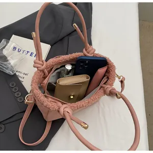 Macro view of pink suede bucket bag with soft plush trim and spacious interior storage