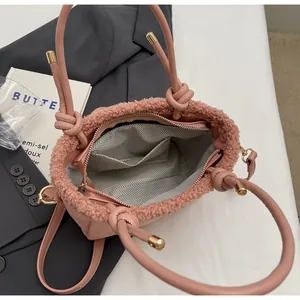 Detail view of pink bucket bag featuring plush trim and wavy patterned inner lining