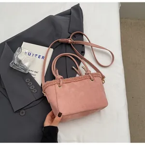 Detailed macro view of pink frosted suede handbag featuring fluffy plush trim and long strap