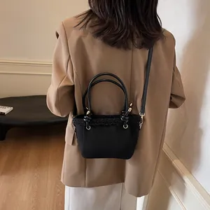 Chic black bucket bag with plush trim shown on a model in a sophisticated indoor setting