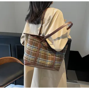 Detail of vintage plaid tote bag featuring brown leather trim and Meiduco brand tag
