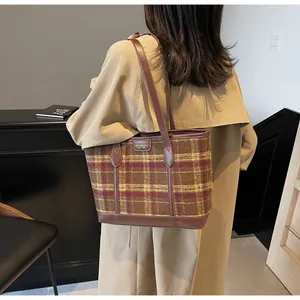 Close-up of retro plaid tote bag showing textured wool fabric and brown leather straps