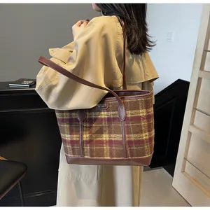 Detail of retro plaid tote bag with wool fabric texture and leather shoulder strap