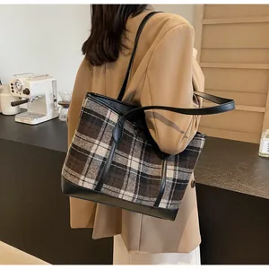Detail of large vintage checkered tote bag in brown wool fabric with leather straps