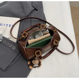 Top view of brown cylinder bag with gold hardware showing interior storage capacity