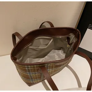 Detail view of plaid tote bag interior with gray lining and secure zipper pocket