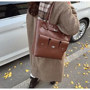 Détails d'un sac cabas marron foncé avec fermoirs en métal argenté et poches à rabat