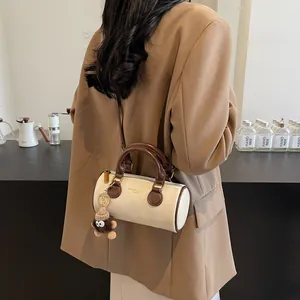 Retro cylinder crossbody bag in cream and coffee with fuzzy monster charm decoration