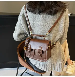 Rear view of model wearing a vintage brown leather satchel with adjustable straps
