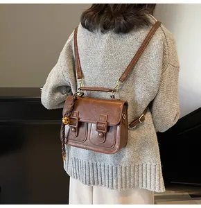 Close-up of vintage brown crossbody bag with metal buckle and decorative bell charm