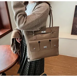 Détail du sac cabas en cuir kaki foncé avec fermoir rotatif argenté et style rétro