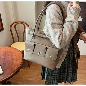 Détail du grand sac cabas taupe avec poche cargo et fermoir rotatif porté par mannequin
