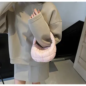 Detail of light pink quilted puff shoulder bag showing soft down texture and fabric finish
