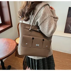 Détails du sac cabas marron kaki avec des poches fonctionnelles et des fermoirs argentés