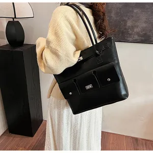 Détails d'un sac cabas en cuir noir avec fermoir rotatif et trois poches pratiques