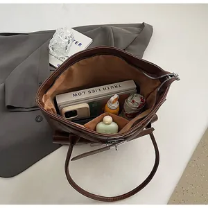 Vue de dessus de l'intérieur du grand sac cabas marron avec compartiments et accessoires