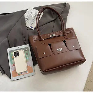 Détail d'un sac cabas marron foncé avec plusieurs poches et finitions argentées