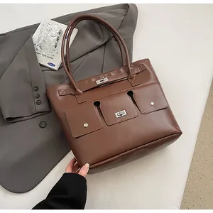 Détail d'un cabas en cuir marron avec fermoirs métalliques et trois poches avant