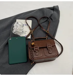 Detailed view of the vintage brown leather satchel with dual buckle pockets and handle