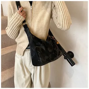 Fashionable black large crossbody bag with woven pendant on model for autumn style