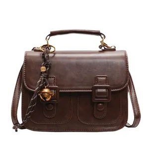 Vintage dark brown crossbody bag in frosted PU leather with top handle and charms