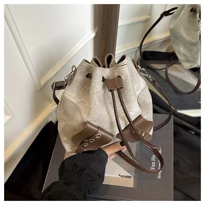 Detail of retro bucket bag in grey canvas and brown leather on a photo book