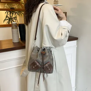 Retro canvas bucket bag in dark gray and brown leather with drawstring closure