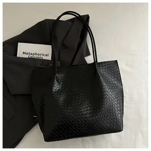 Close-up of black tote bag featuring premium woven texture and glossy faux leather finish